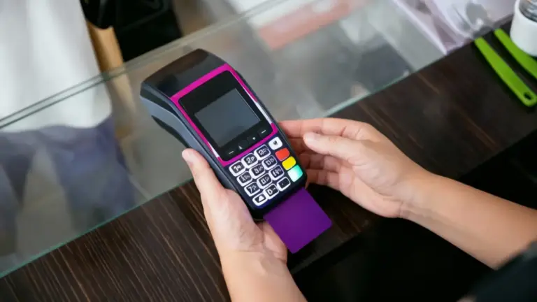 Una persona tiene un terminal POS con una carta inserita